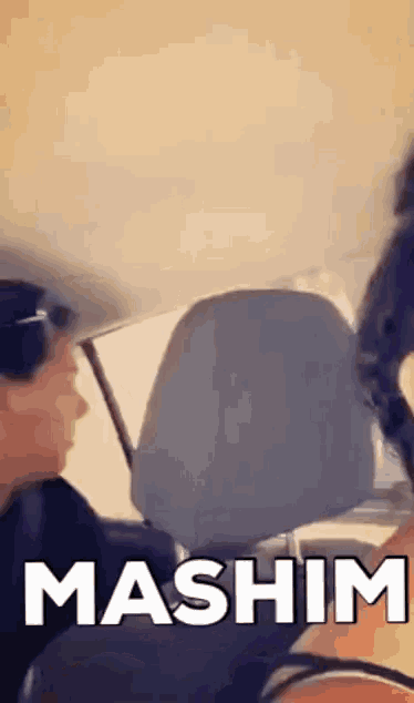 a man and woman are sitting in a car with mashim written on the screen