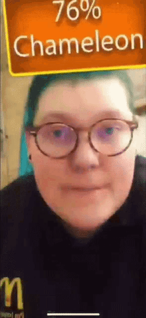a person with glasses and a sign that says chameleon on it