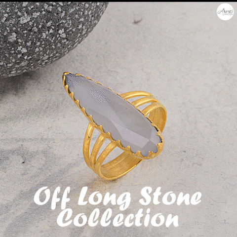 a gold ring with a green stone sits on a table with the words off long stone collection above it