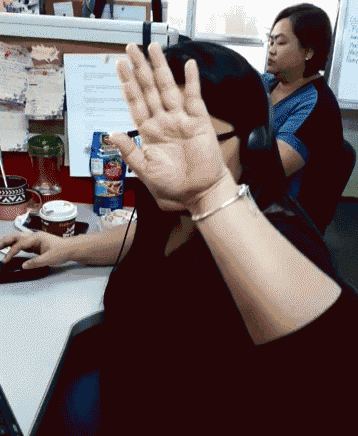 a woman wearing headphones and a bracelet is waving