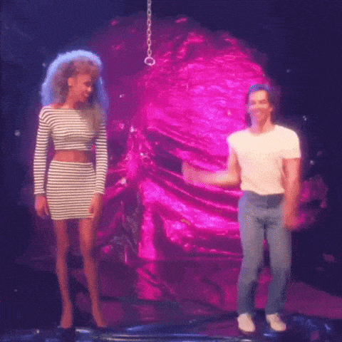 a man and a woman are dancing on a stage in front of a pink cloth .