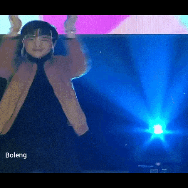 a man wearing a face shield is dancing in front of a projector screen that says boleng