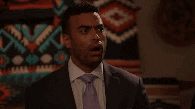 a man in a suit and tie has his mouth open