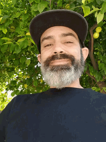 a man with a beard wears a black hat