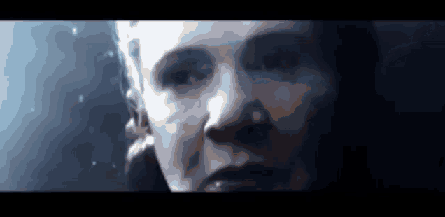 a close up of a woman 's face in a dark room in a movie .