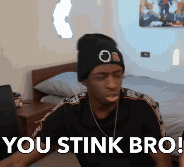 a man wearing a beanie and a black shirt says you stink bro