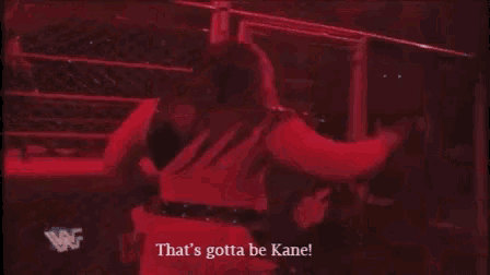 a person in a pink outfit is standing in a boxing ring with the words `` that 's gotta be kane '' .