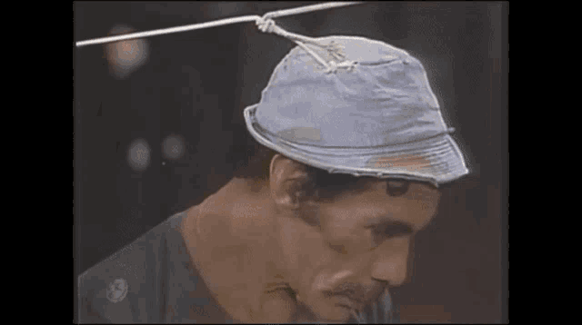 a man wearing a hat is tied to a wire