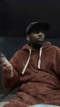 a man wearing a hat and a hoodie with the letter t on it