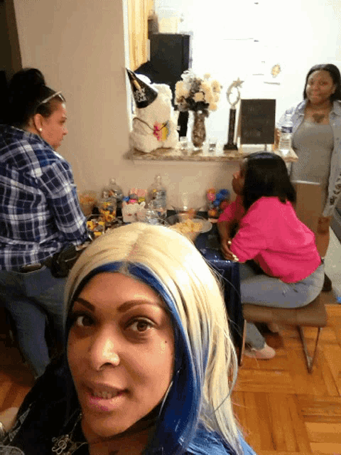 a woman with blonde hair and blue streaks is sitting at a table