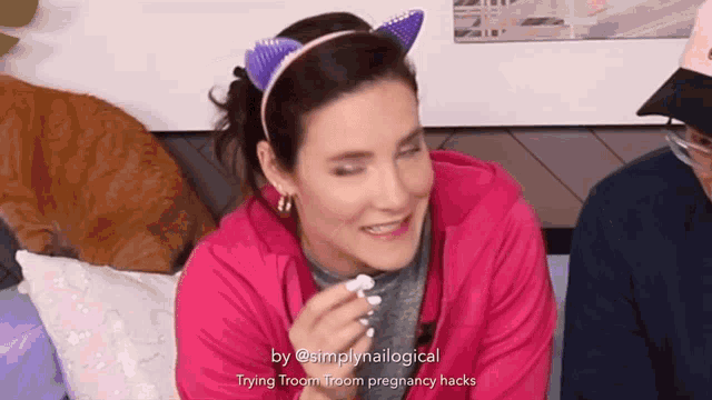 a woman wearing a cat ear headband is laughing with the caption trying room room pregnancy hacks below her