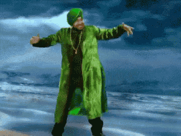 a man in a green turban and green coat is dancing