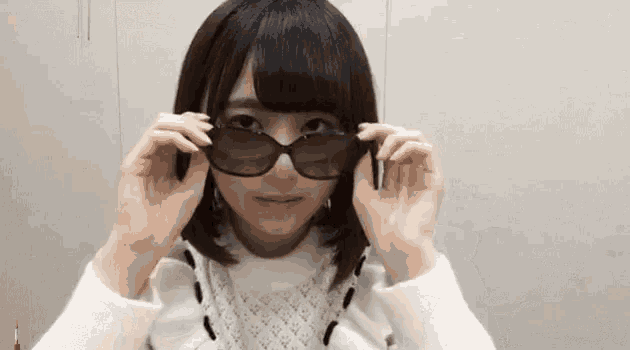 a young woman is wearing sunglasses in front of her face .