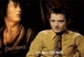 a man in a yellow jacket and tie is sitting in front of a woman in a black jacket .
