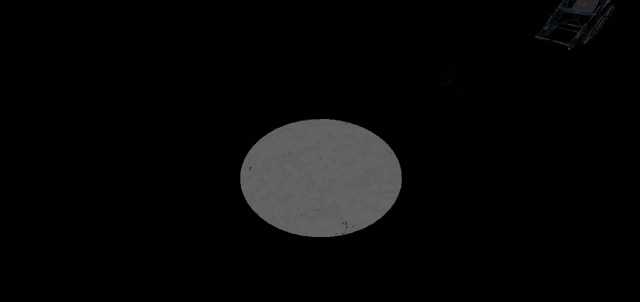 a wheelchair is sitting in a dark room next to a stool .
