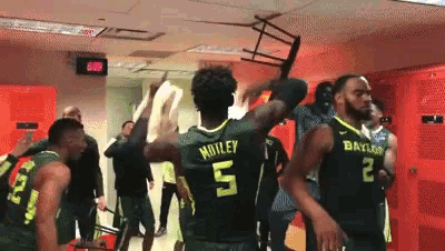 basketball players in a locker room with one wearing the number 5