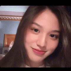 a close up of a woman 's face with long hair and a smile on her face .