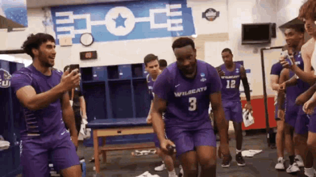 a group of basketball players are in a locker room and one of them is wearing a number 3 jersey