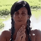 a woman in a bikini is holding her hands together in prayer .