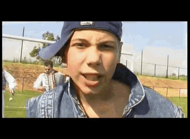 a young boy wearing a blue hat with reebok on it