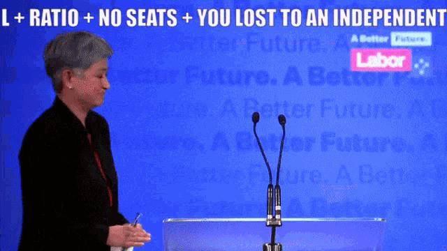 a woman stands at a podium with the words l + ratio + no seats + you lost to an independent on the back