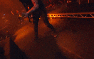 a man in a black shirt is playing a guitar on stage