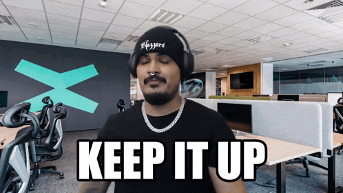 a man wearing headphones and a black shirt says keep it up