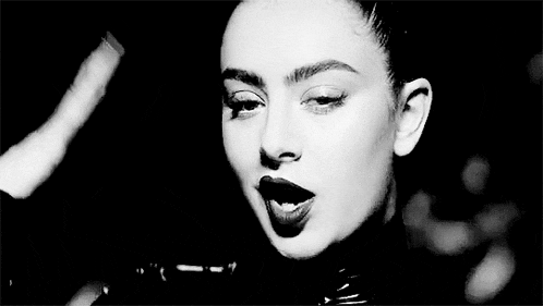 a black and white photo of a woman wearing a leather jacket and lipstick .