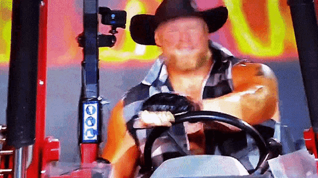a man wearing a cowboy hat is driving a red forklift