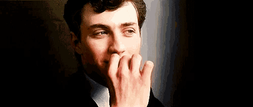 a man is smoking a cigarette in a suit and tie .