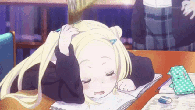 a blonde anime girl is sleeping on a book