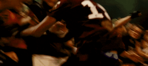 a man is holding a megaphone in front of a crowd of people with one wearing a number 7 jersey
