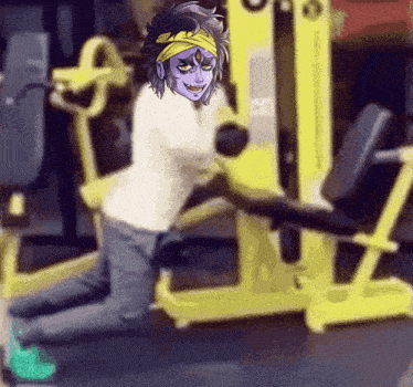 a person is kneeling down in front of a yellow machine .