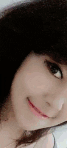 a close up of a woman 's face with her eyes closed and a smile .