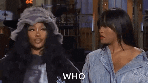 two women are standing next to each other and talking to each other . one of the women is wearing a fur hat .