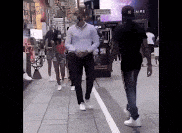 a man in a white shirt and black pants is walking down a sidewalk in front of a citizen store