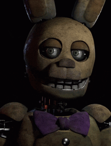a stuffed bunny with a purple bow tie is smiling