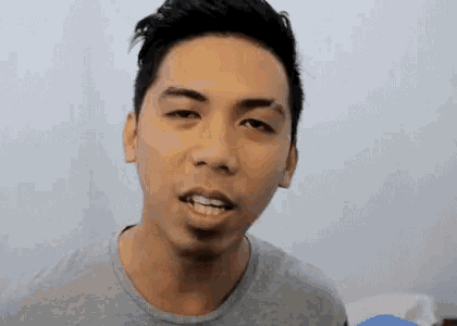 a young man with a beard is making a funny face .