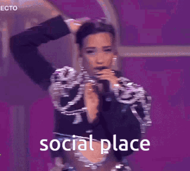 a woman singing into a microphone with the words social place written on the bottom