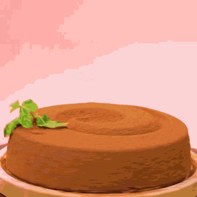 a chocolate cake with a slice taken out of it on a pink background