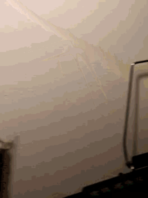 a person standing in front of a white wall with a metal railing