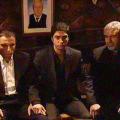 a group of men sitting in front of a picture of a man