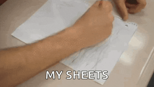 a man in a red shirt is sitting in a classroom and saying `` my sheets '' .
