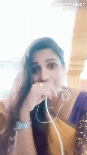 a woman is wearing headphones and covering her mouth .