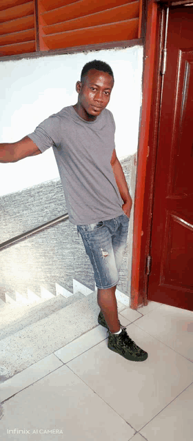 a man standing in front of a door with a infinix ai camera displayed on the bottom right