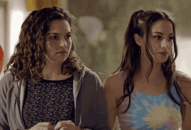two women are standing next to each other and one is wearing a tie dye top