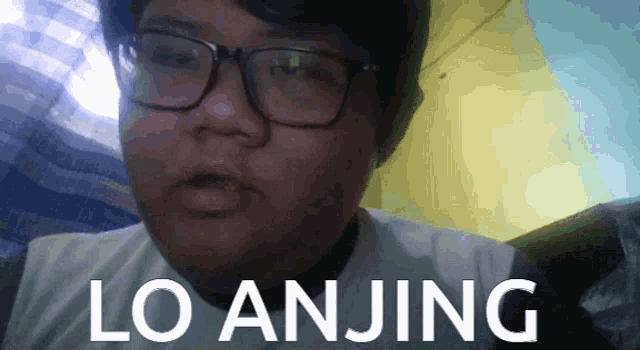 a man wearing glasses and a white shirt with the word lo anjing on it