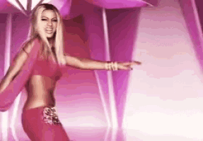a woman in a pink dress is dancing on a stage .