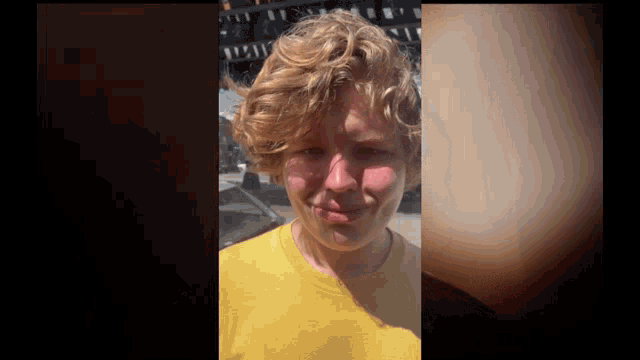 a young man with curly hair wearing a yellow shirt
