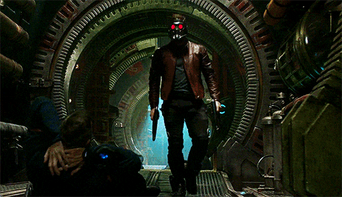 a man in a skull mask is standing in a dark room